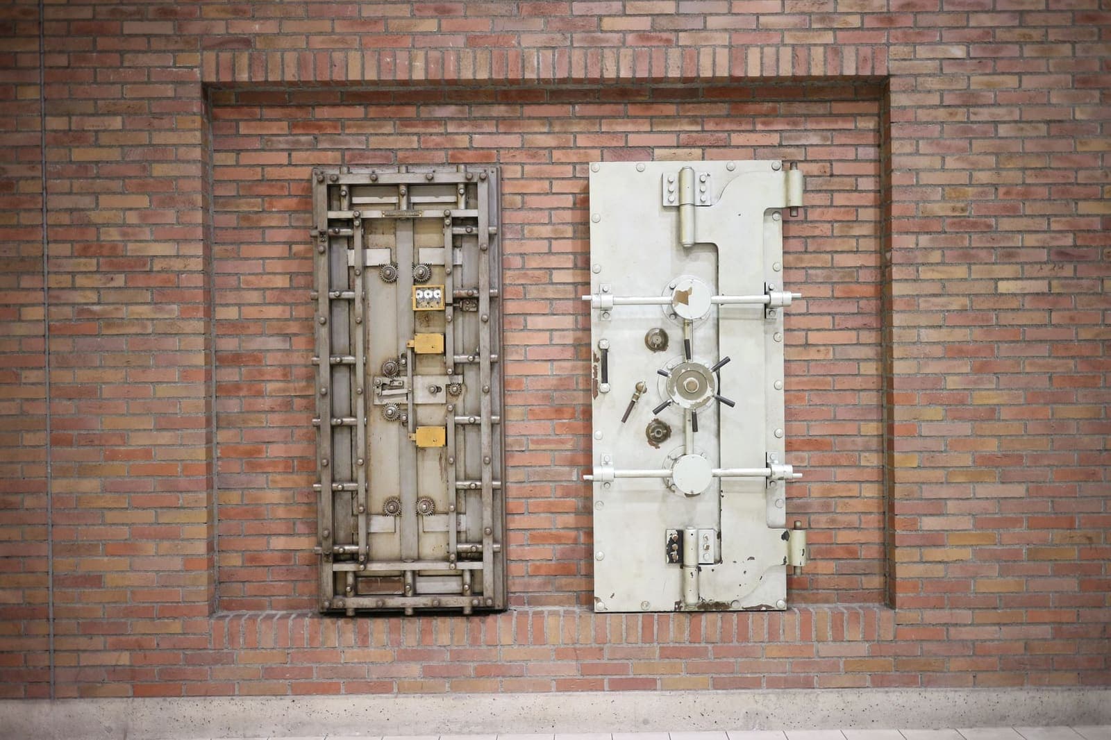 Twee stalen kluisdeuren in een bakstenen muur