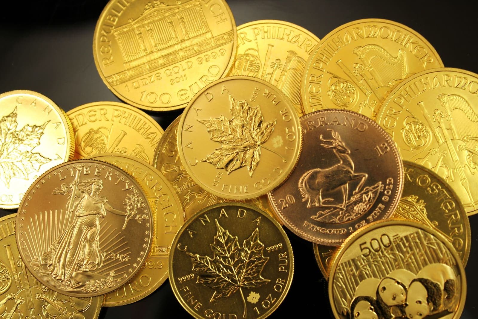 Gouden beleggingsmunten van verschillende munthuizen naast elkaar